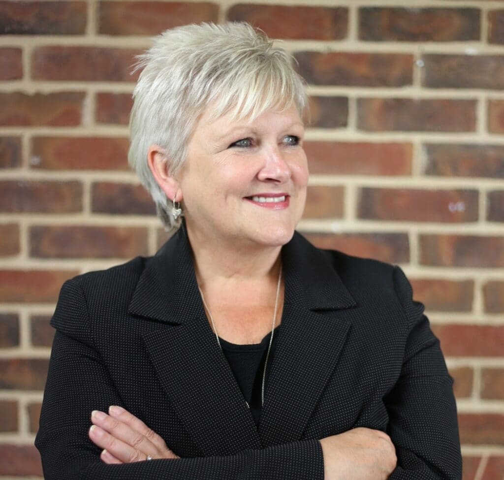 Jayne Griffiths-Scott Notary Public, smiling, looking into the distance.